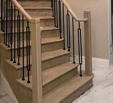 A modern wooden staircase with a metal balustrade.