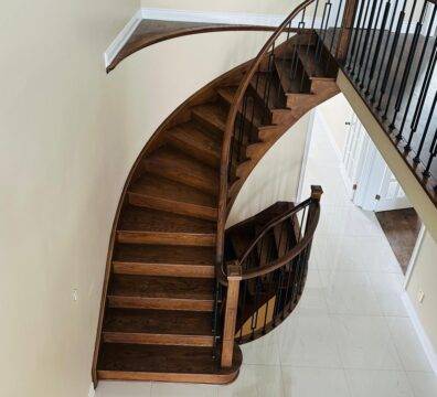 A beautiful spiral wooden staircase with a balustrade.