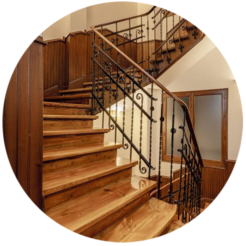 A vintage wooden staircase with iron railings.