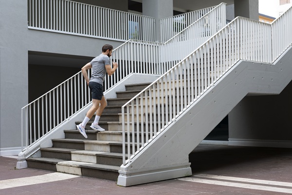 Man running up modern outdoor stairs.