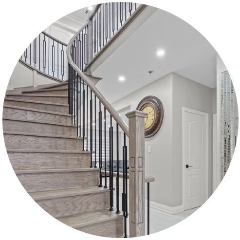 Grand staircase with wood treads and metal railing.