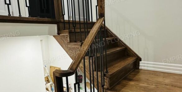 A renovated staircase with dark wood and iron railing.
